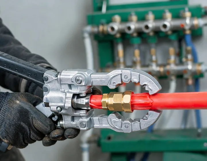 Technician expanding PEX-a tubing onto a ProPEX fitting at a jobsite